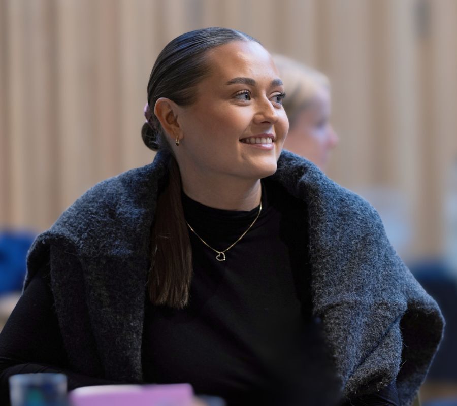 Professional listening during a business event, representing continuous compliance and connected control in modern organizations.